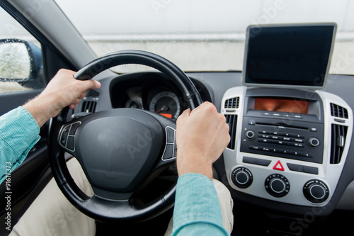 close up of young man with tablet pc driving car