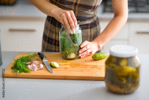 Closeup of woman's hands preparing cucumbers for dill pickles