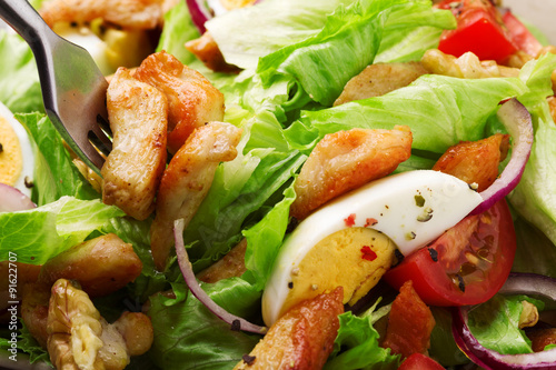 Delicious salad with chicken, nuts, egg and vegetables.