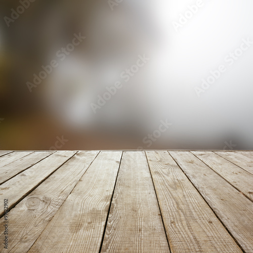 Wooden perspective floor with planks on blurred natural autumn background  can use for display or montage your products. template. Copy space