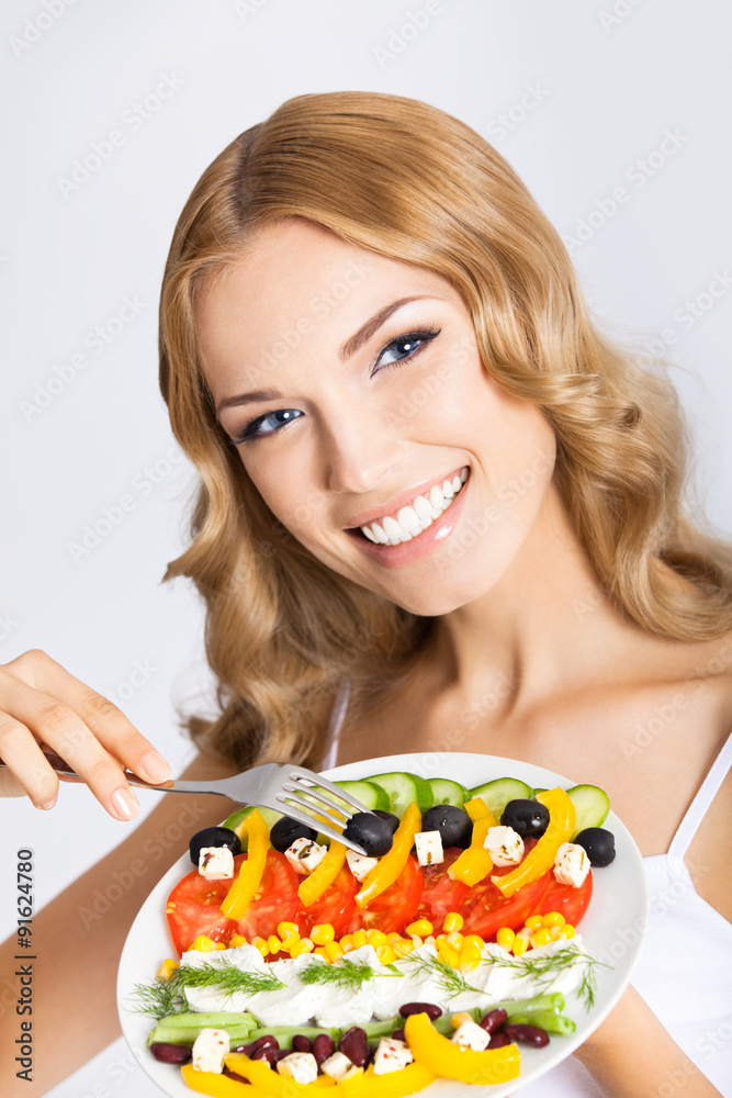 Woman with vegetarian salad, over gray Woman with vegetarian salad, over gray