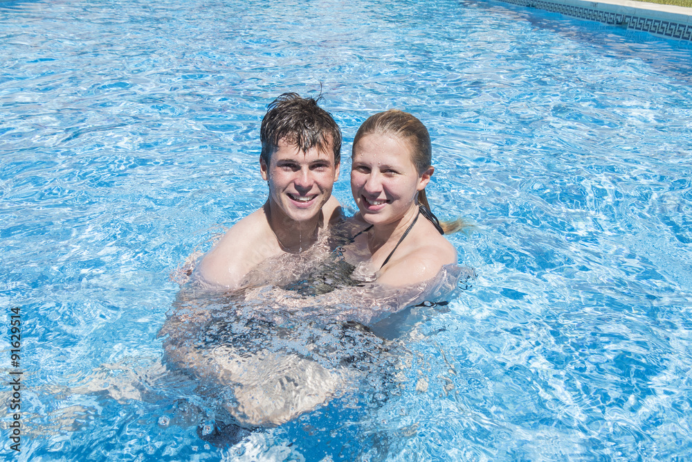 Smiling young couple enjoying the pool in summer