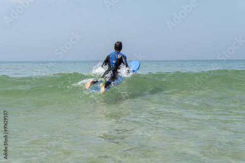 Young boy surfing in the sea