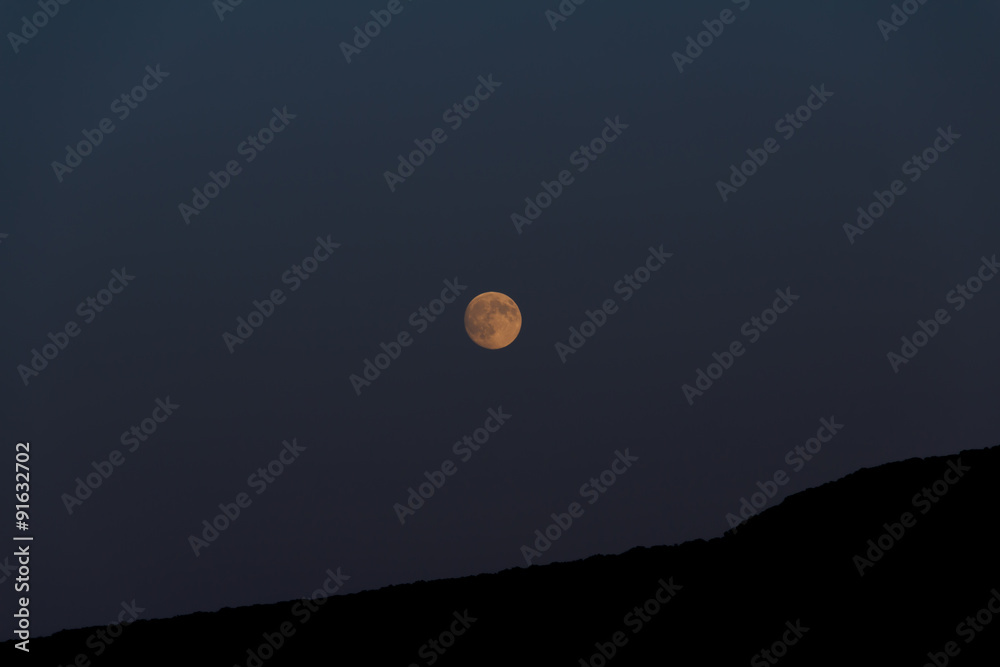 Big moon shines over the mountain. Night