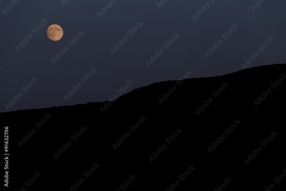 Big moon shines over the mountain. Night Big moon shines over the mountain. Night