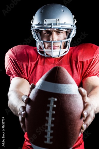 Portrait of confident sportsman showing American football