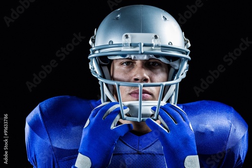Portrait of serious sportsman holding helmet
