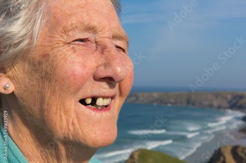 Εκτύπωση καμβά Old lady pensioner with dental problems and tooth missing by coast scene