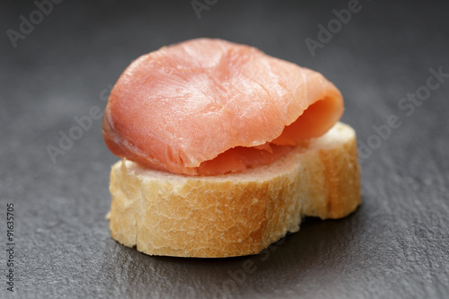 baguette slice with curred salmon on slate