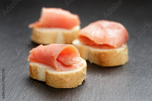 baguette slices with curred salmon on slate