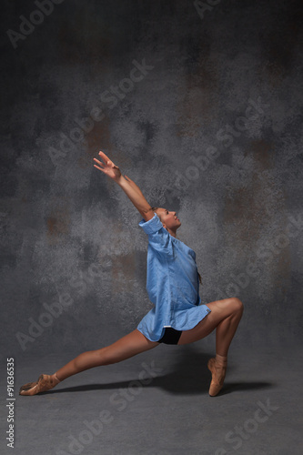 Young beautiful modern style dancer posing on a studio