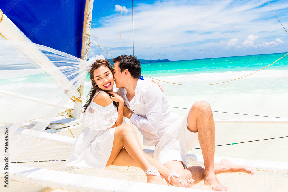 Young beautiful couple having fun on a tropical beach . Tropical