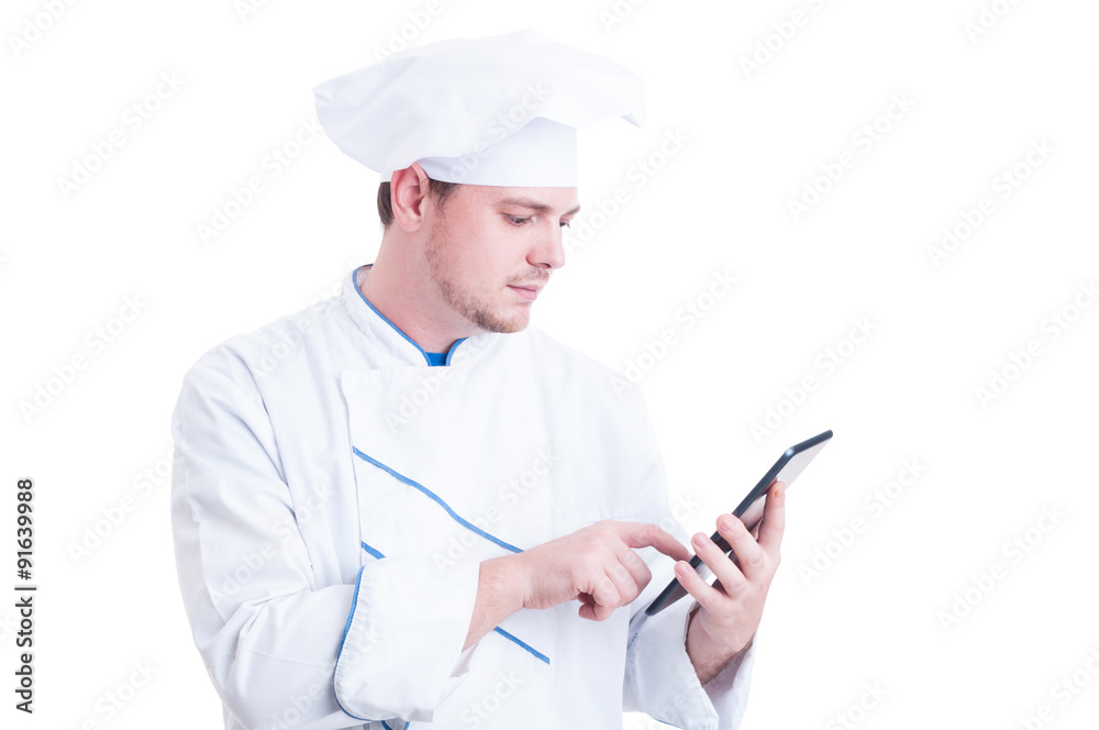 Modern cook or chef using a wireless tablet pc Modern cook or chef using a wireless tablet pc