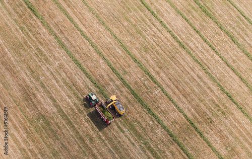 aerial view of harvest field with tractor and combine