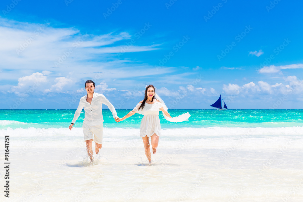 Happy groom and bride on the sandy tropical beach. Wedding and h Happy groom and bride on the sandy tropical beach. Wedding and h