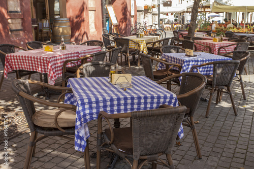 restaurant summer terrace with table-cloth covered tables and wicker chairs