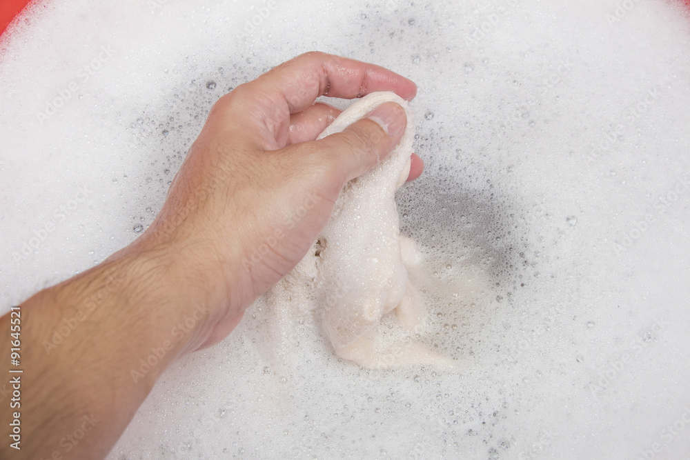 Fototapeta premium Hand washing clothes with soapy water