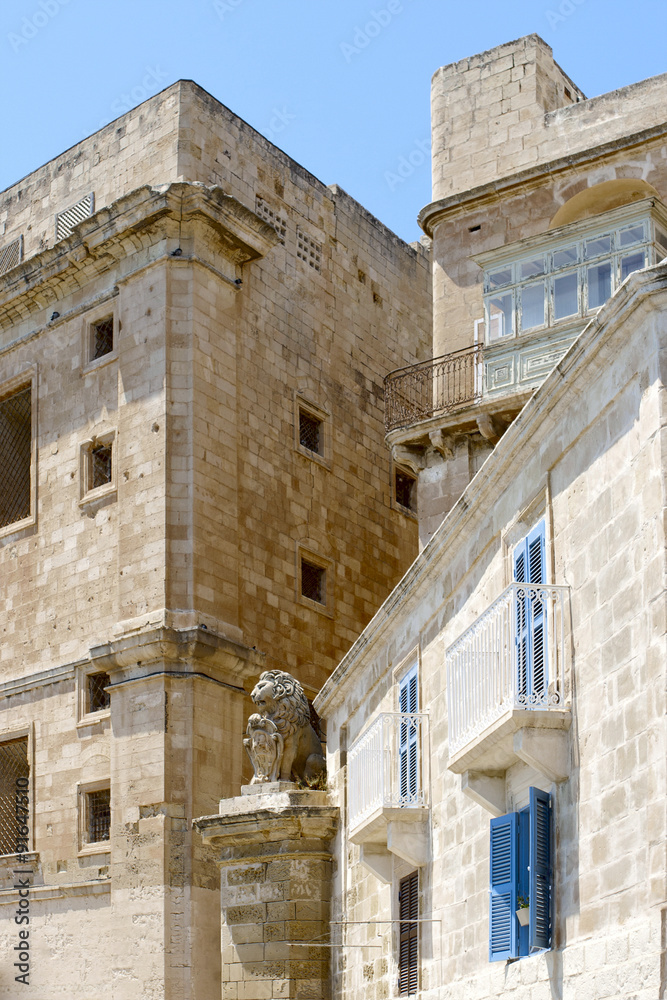 Maltese houses with a lion statue