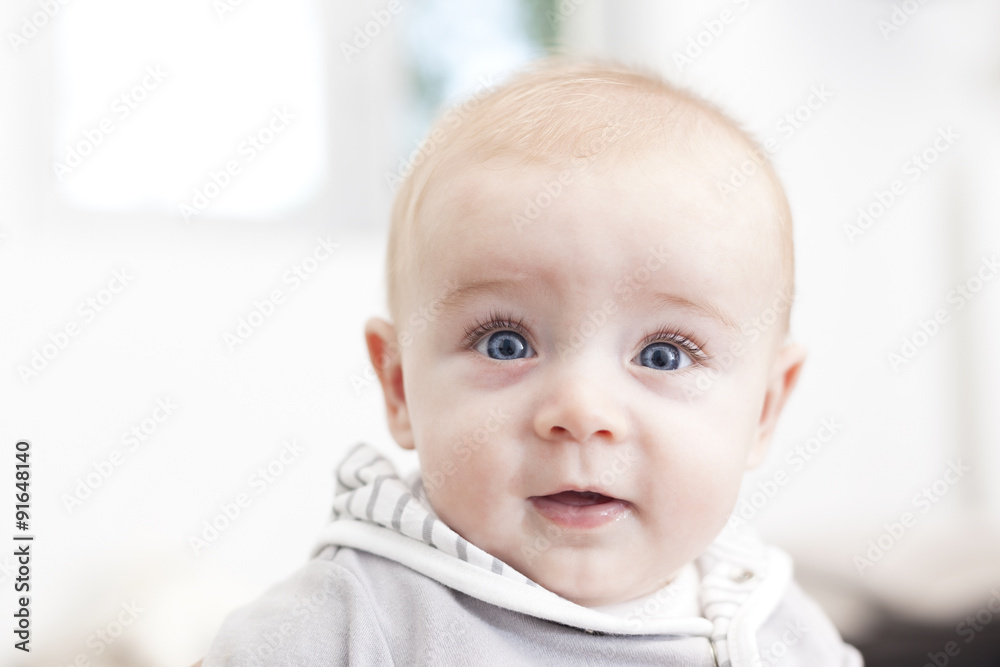 Baby with blue eyes looking to the camera and smiling