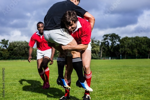 Photography Rugby players tackling during game