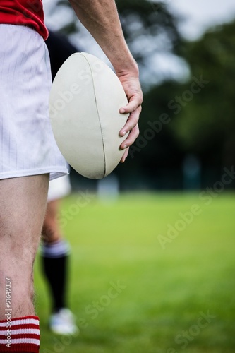 Rugby player standing with ball