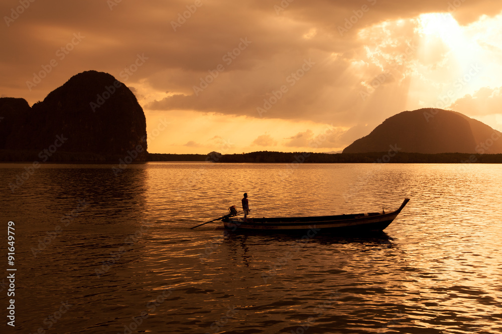 Silhouette of fisherman and traditional thai boats at Sam chong