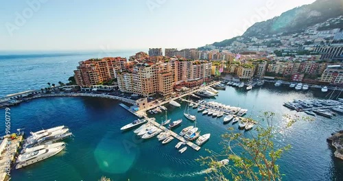 Monaco, Fontvieille, 29.08.2015: View from the Monaco village, Palace Square Prince of Monaco at sunset, the famous port, oil spots on the water, helicopters, luxury apartments, azure water, yacht, 4k
