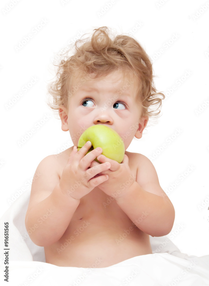 portrait of a child curly hair eats a green аpple on white back