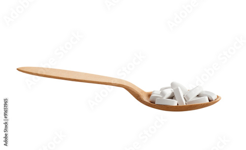 wooden spoon with pills isolated