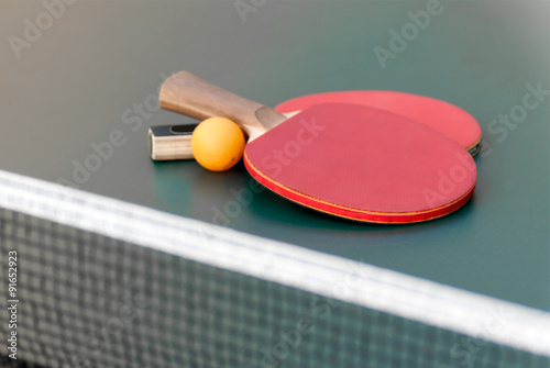 two tennis racket and a ball on the table with a grid