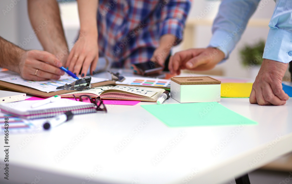 Close-up of three young creative designers working on project