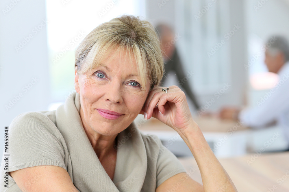 Portrait of smiling senior woman, people in background Portrait of smiling senior woman, people in background