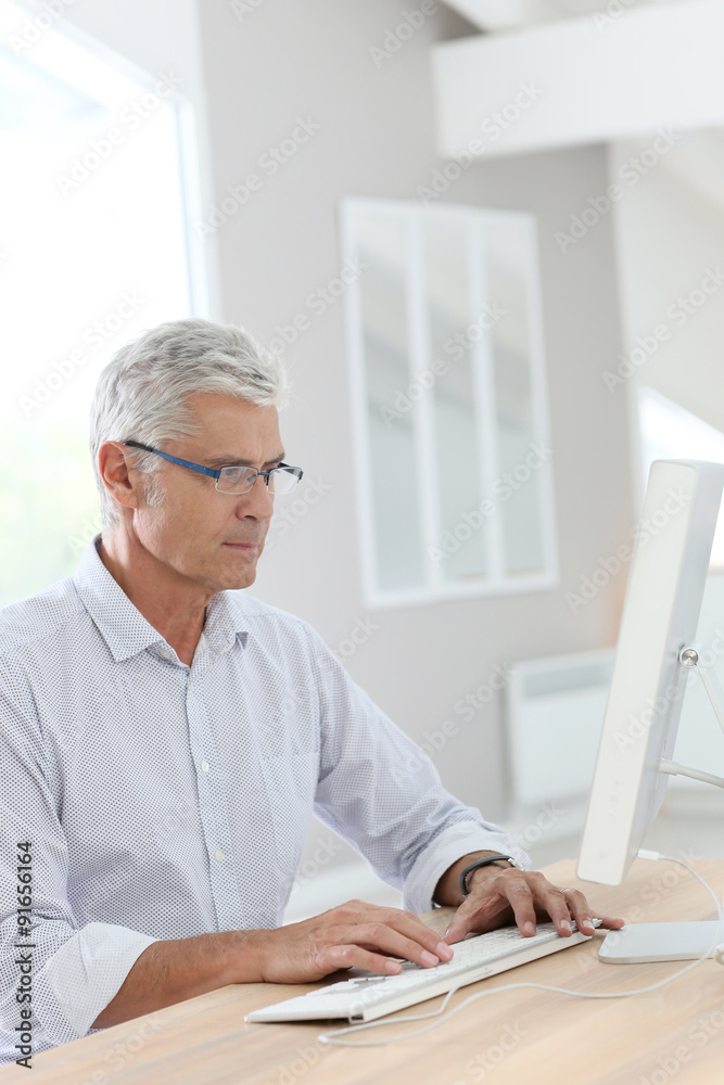 Senior man connected on desktop computer Senior man connected on desktop computer