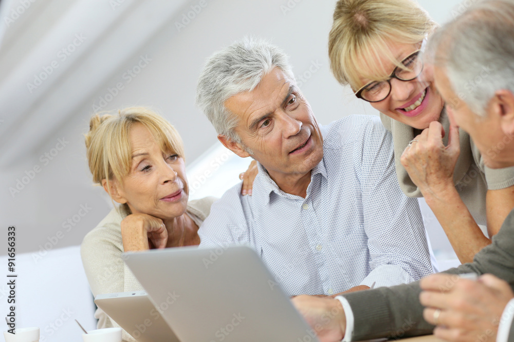 Group of retired senior people using laptop and tablet