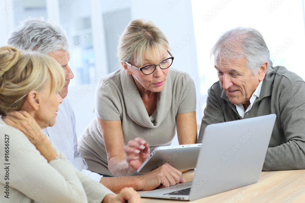 Group of retired senior people using laptop and tablet