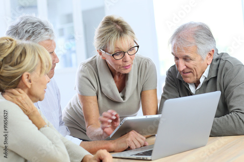 Group of retired senior people using laptop and tablet © goodluz