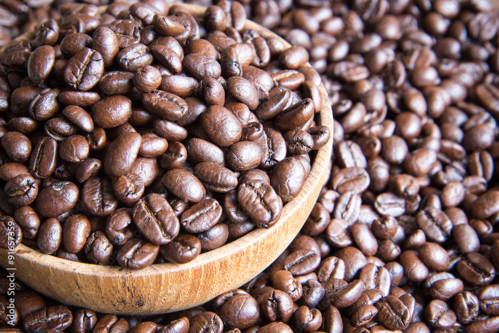 roasted coffee beans in wooden bowl with coffee background roasted coffee beans in wooden bowl with coffee background