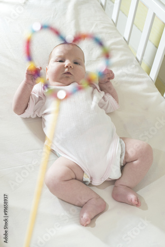 Baby in a bed in frame of heart shape. photo