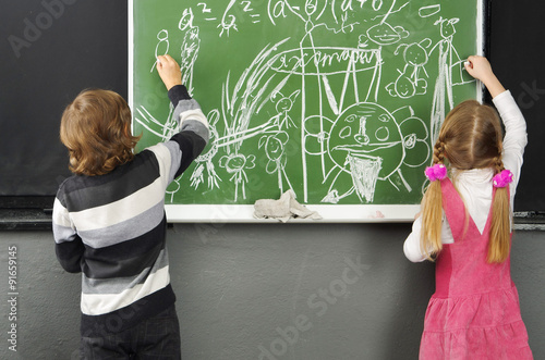 Дети рисуют на доске.Школа, класс, мальчик и девочка у школьной доски