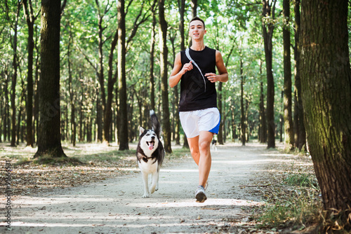 work out with dog. Young caucasian male running with siberian hu
