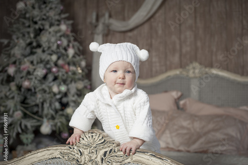 Маленькая  девочка в белой шапочке с помпонами 