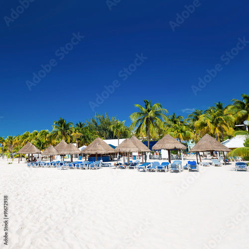 Caribbean beach with sun umbrellas and beds
