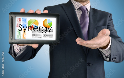 Businessman showing business concept on tablet - Synergy