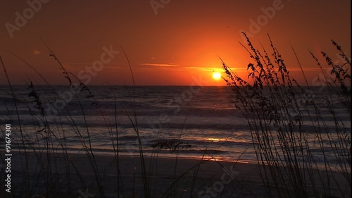 WS of sunrise at the beach through sea oats