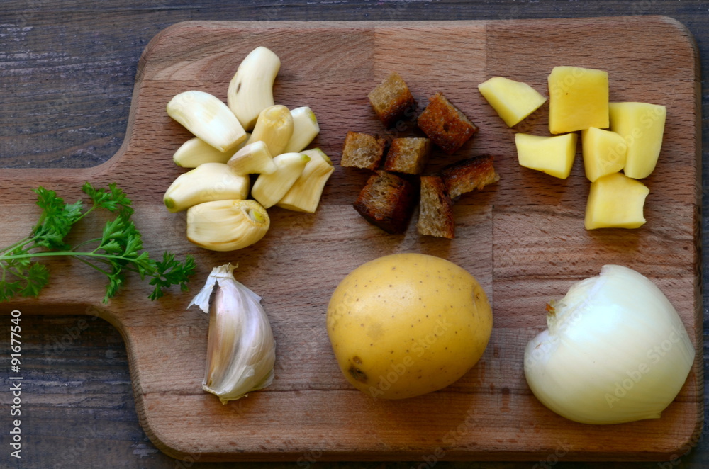 Fototapeta premium Ingredients for garlic soup on chopping board