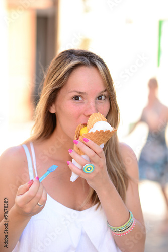 Portrait of young happy woman eating ice-cream outdoor