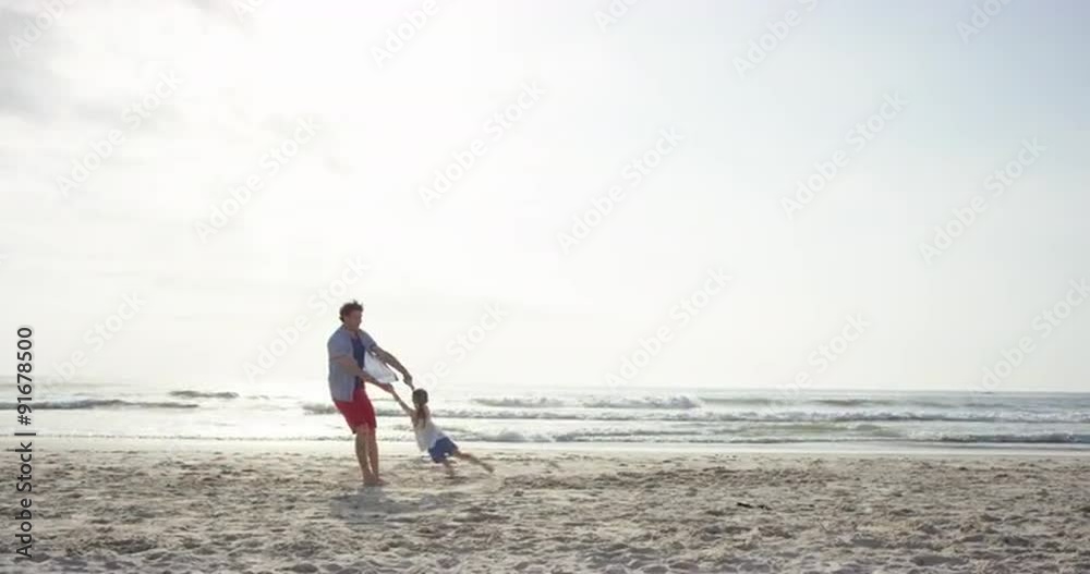 Father swinging daughter around on the beach at sunset having fun Father swinging daughter around on the beach at sunset having fun