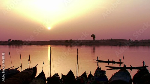 Fishermen row at sunset on the Niger River in beautiful golden light in Mali, Africa. photo