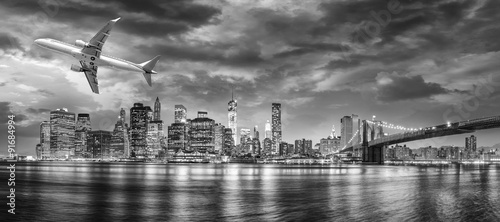 Black and white view of airplane overflying New York City #91684994