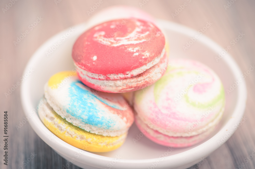 A lot of french colorful macarons The plate on wood background i